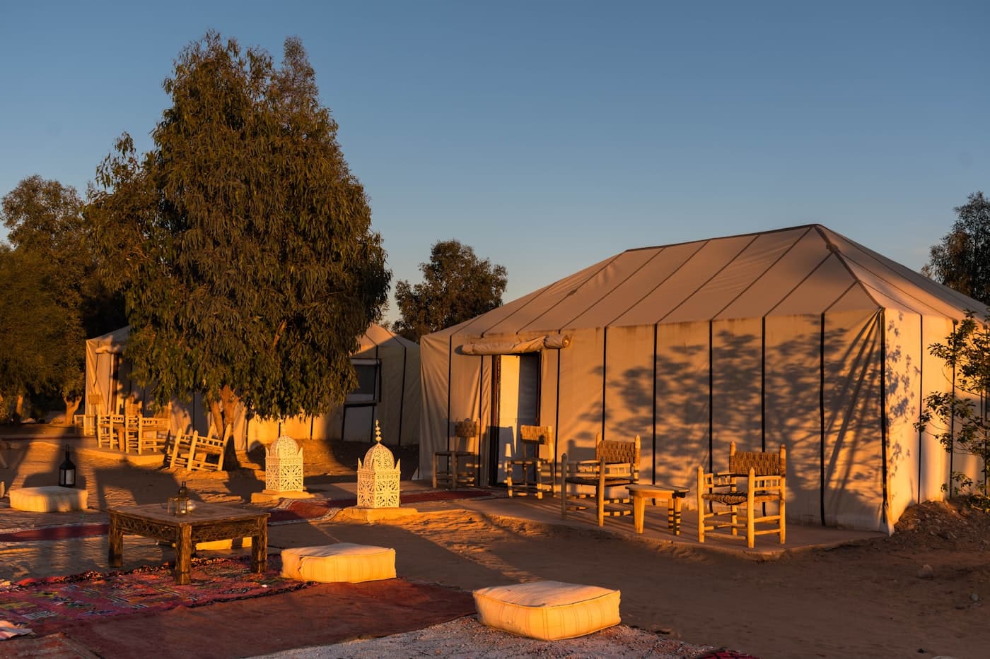 A luxury desert camp tent glowing at dusk in the Sahara