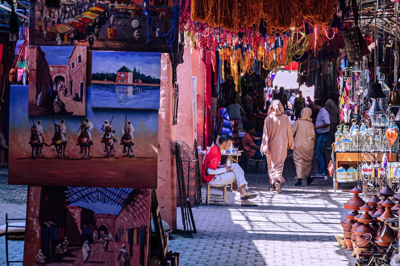 Handwoven rugs and lanterns lining a covered market lane