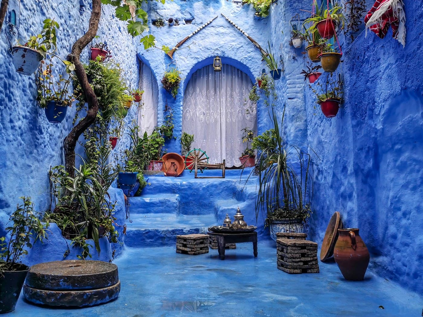 A cobalt-blue doorway and planted courtyard in Chefchaouen